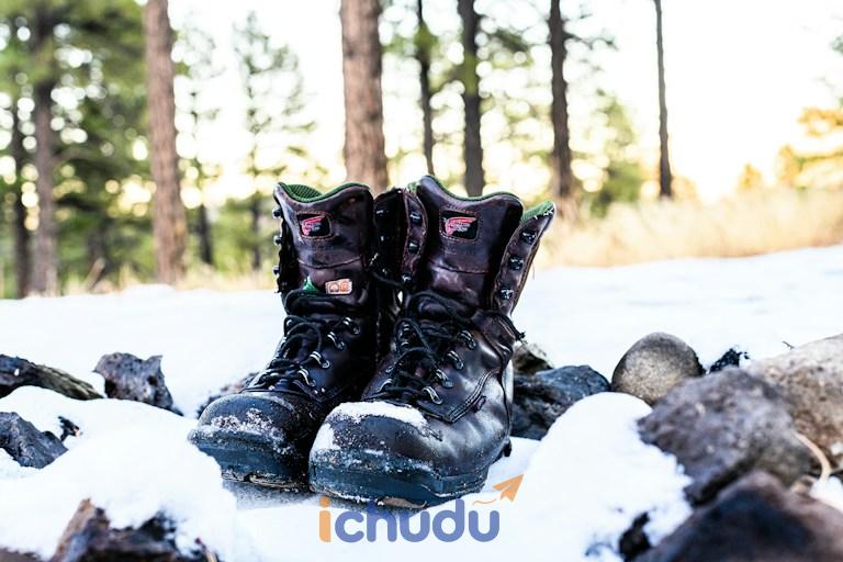 Đôi giày boot đi tuyết đặt trên nền tuyết trắng